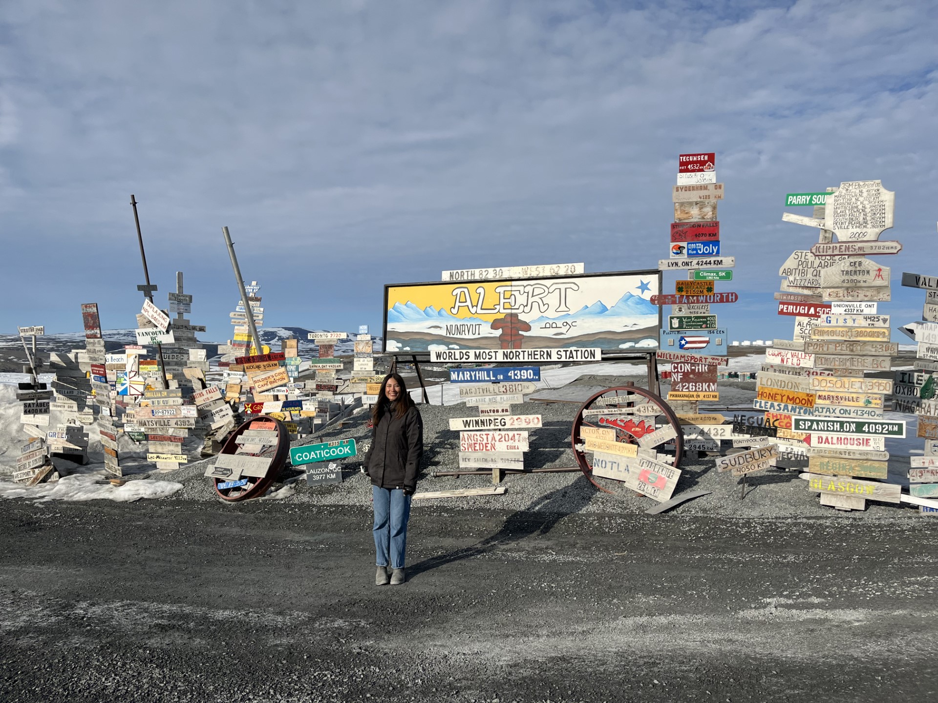 Erika Bullen in front of Alert, Nunavut signs