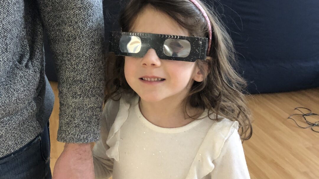 Ella Phillips wears her eclipse glasses after a Faculty of Science planetarium show