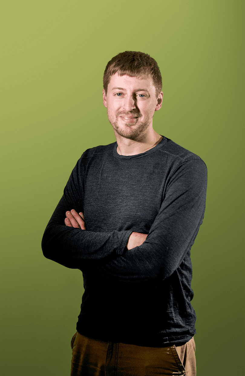 A portrait of Alex Peace in front of a green backdrop. Image 1 of 1
