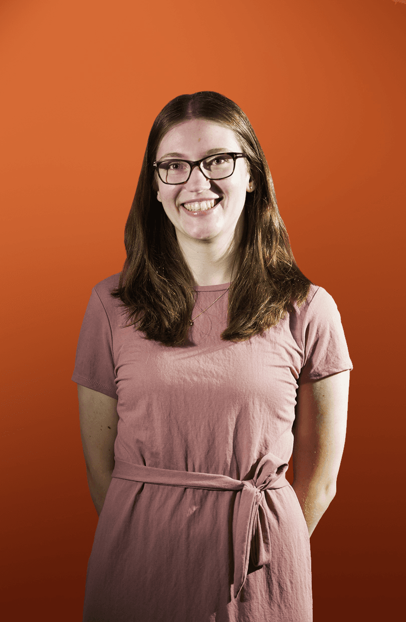 A portrait of Megan Oxland in front of a orange backdrop. Image 1 of 1
